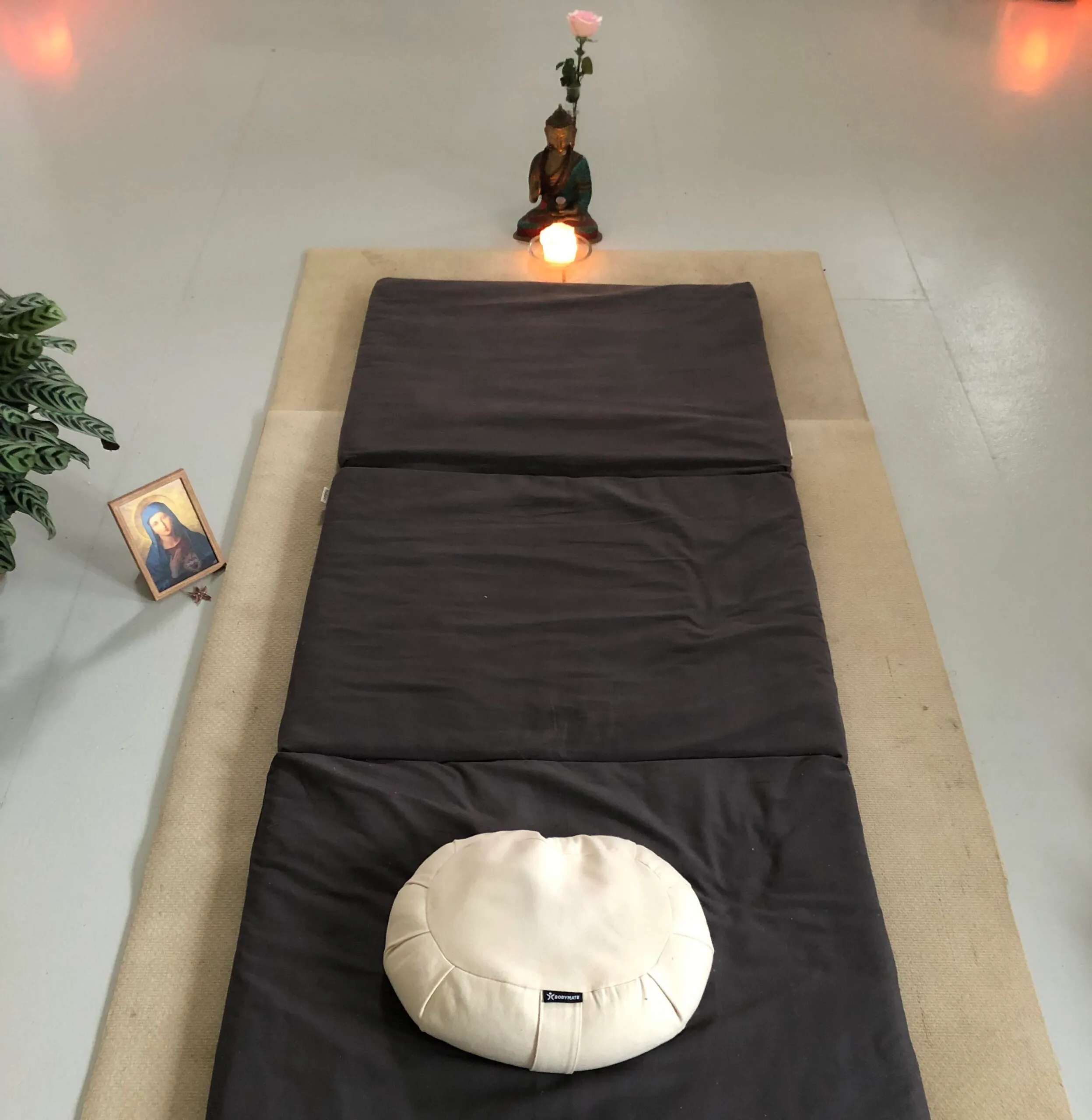 Meditationsrum med måtte, pude og et lille alter